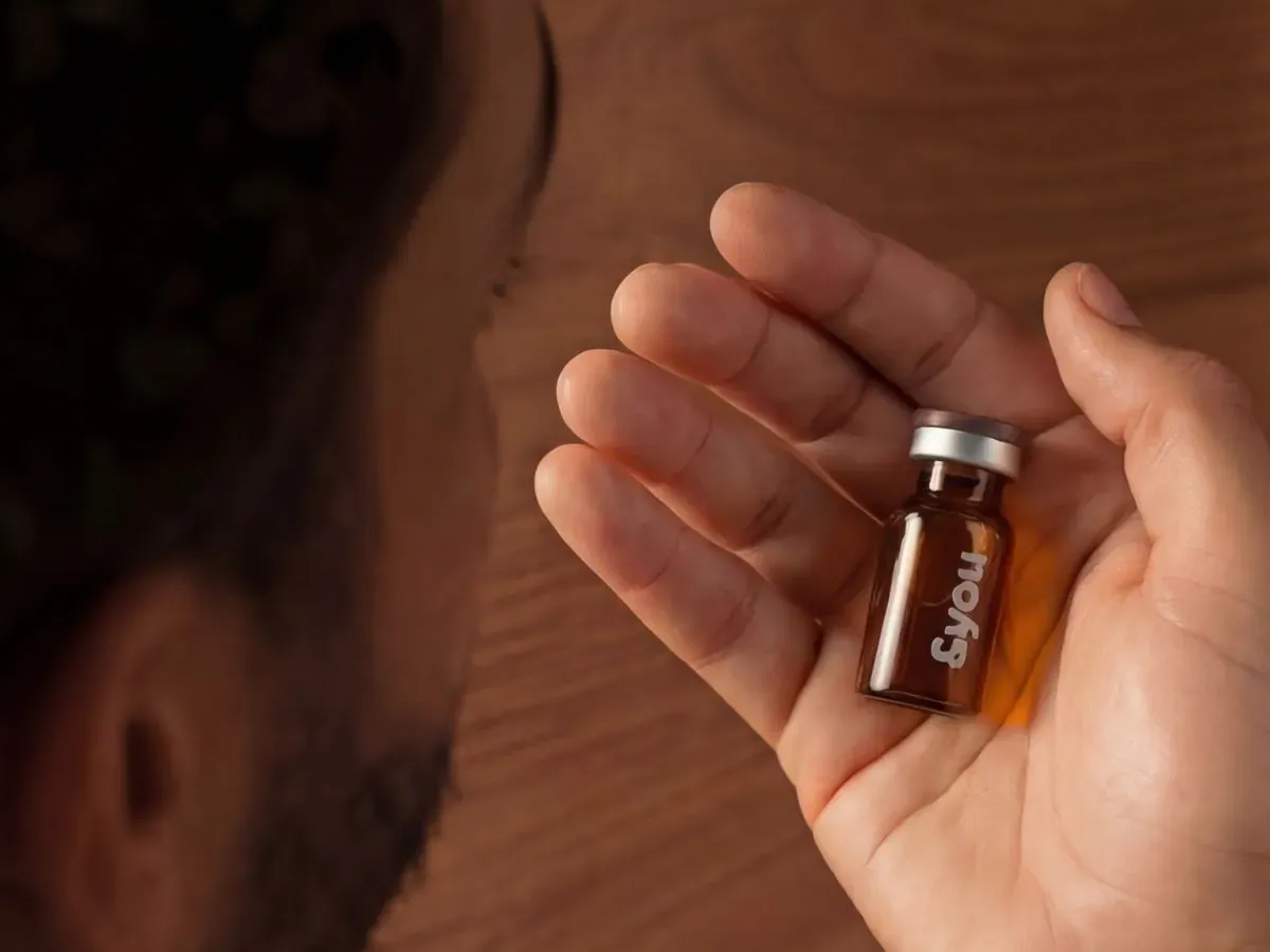 Man holding an &you medicine vial